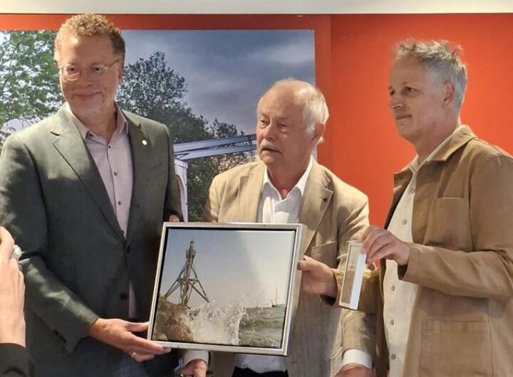 Wethouder Dennis Boutkan ontvangt van Fred Veerman en Marco Wohlken op symbolische wijze het idee voor het burgerinitiatief voor de wisselexpositieruimte.