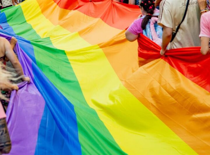 Deelnemers lopen mee tijdens de Pride Walk in Hoorn tijdens de Regenboogweek, met regenboogvlaggen en aandacht voor inclusiviteit.