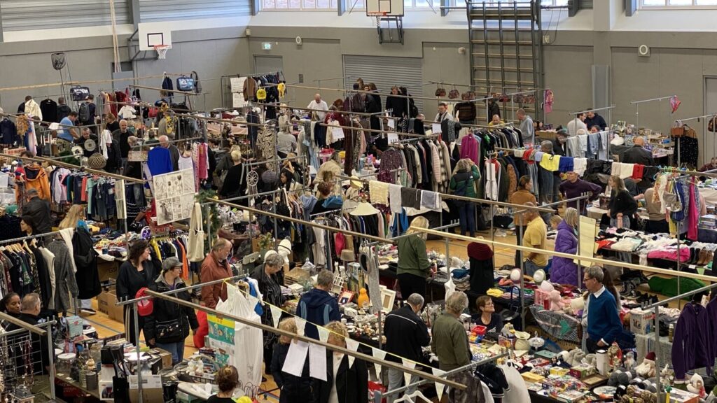 Bezoekers struinen langs kraampjes op een drukbezochte vlooienmarkt in Sporthal De Kreek in Zwaag.