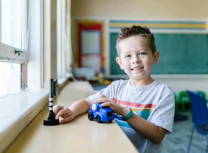 boy playing with blue car toy