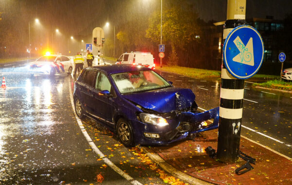 Zwaar beschadigde auto na een botsing tegen een verkeerslicht op de Provincialeweg bij de Rijnweg in Hoorn.